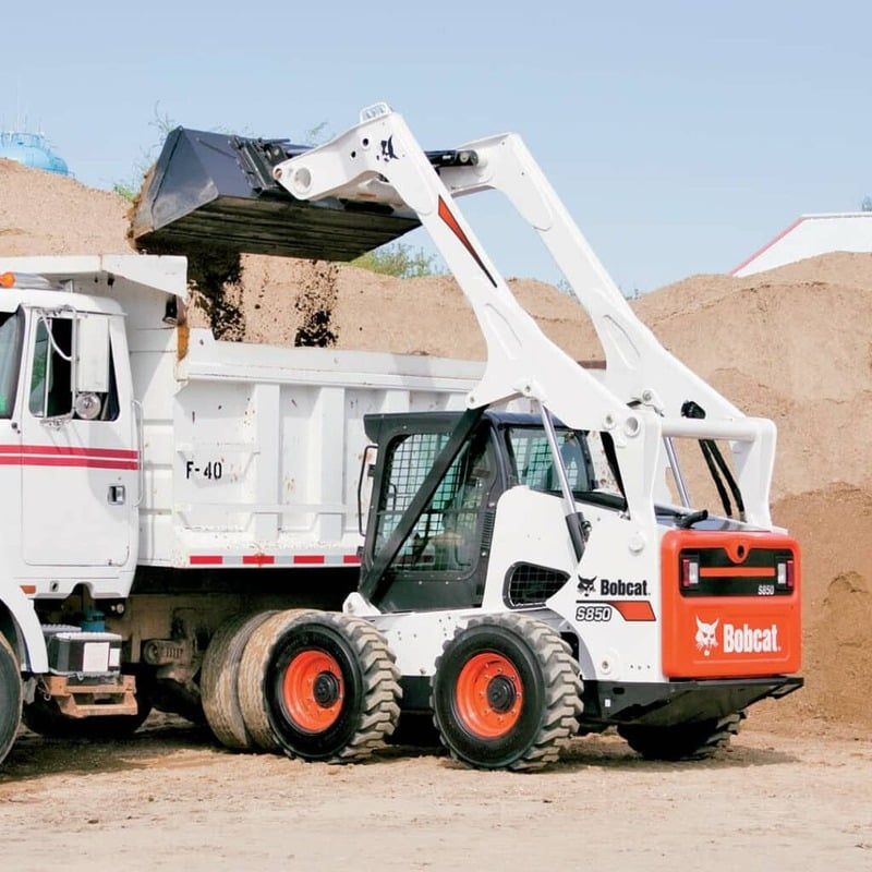 Skid steer loading a dump truck